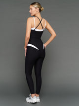 Model is wearing spliced jumpsuit in melt black white, back full body view.