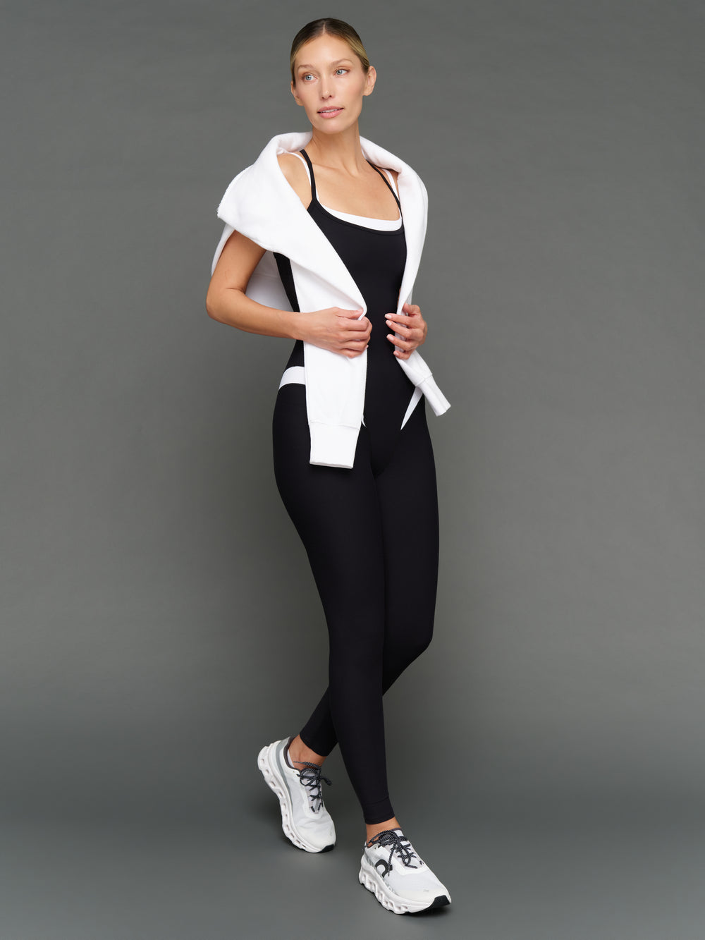 Model is wearing spliced jumpsuit in melt black white with layered jacket, styled full body look.