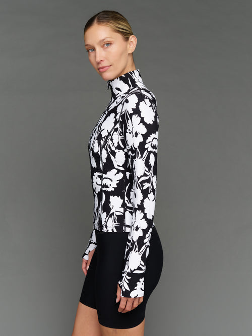 Model is wearing melt full zip jacket floral print, side view.