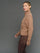 Model is wearing interlock full zip jacket caribou, side profile view.