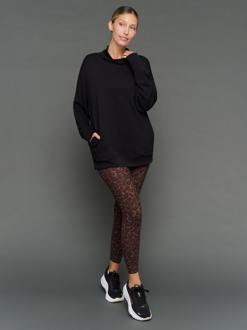 Model is wearing interlock mock neck pullover black, front full body view.