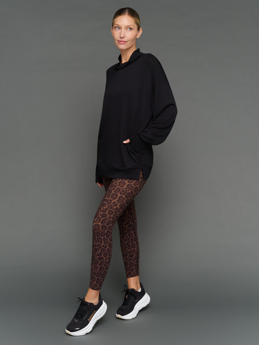 Model is wearing interlock mock neck pullover black, front three-quarter view.