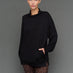 Model is wearing interlock mock neck pullover black, front close-up view.