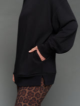Model is wearing interlock mock neck pullover black, pocket detail close-up.