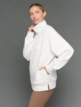Model is wearing interlock mock neck pullover moonbeam heather, side view.