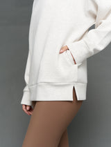 Model is wearing interlock mock neck pullover moonbeam heather, close-up pocket detail.