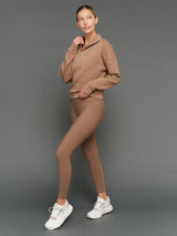 Model is wearing interlock half zip pullover caribou with matching leggings, full body styled view.