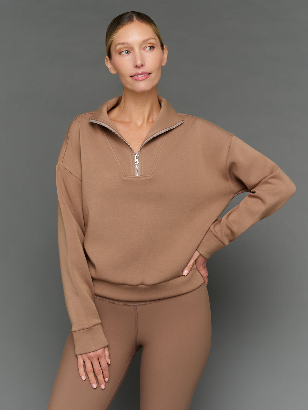 Model is wearing interlock half zip pullover caribou, front upper body view.