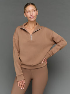 Model is wearing interlock half zip pullover caribou, front upper body view.