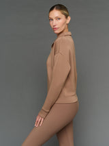 Model is wearing interlock half zip pullover caribou, side profile view.