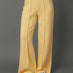 Model wears yellow interlock pants against a grey background.