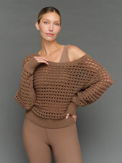 Model is wearing wide neck open knit sweater in caribou, front close-up view.