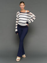 Model is wearing wide neck open knit sweater white navy, front full body view.