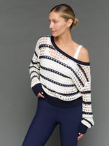 Model is wearing wide neck open knit sweater white navy, side angle view.