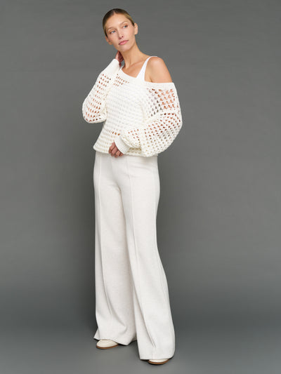 Model is wearing wide neck open knit sweater white, front full body view.