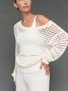 Model is wearing wide neck open knit sweater white, front close-up view.