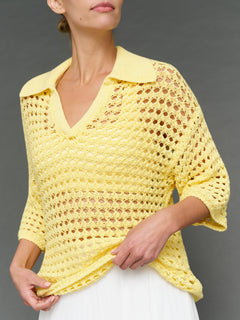 Model is wearing open knit polo sweater pale banana, front close-up detail.