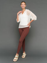 Model is wearing open knit polo sweater white, front full body view.