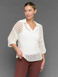 Model is wearing open knit polo sweater white, front view.