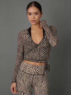 Model wears a zebra print mesh wrap top against a grey background