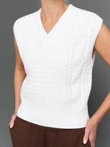 White textured sleeveless top worn by a person on a gray background