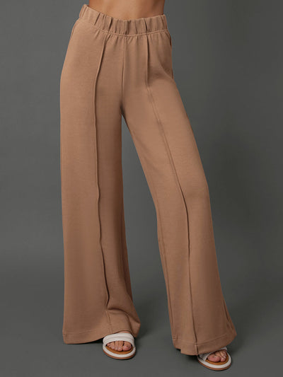 Model wears interlock pants in Caribou against a grey background.