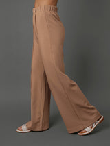 Model wears interlock pants in Caribou against a grey background, side view.