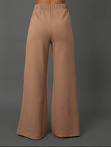 Model wears interlock pants in Caribou against a grey background, back view