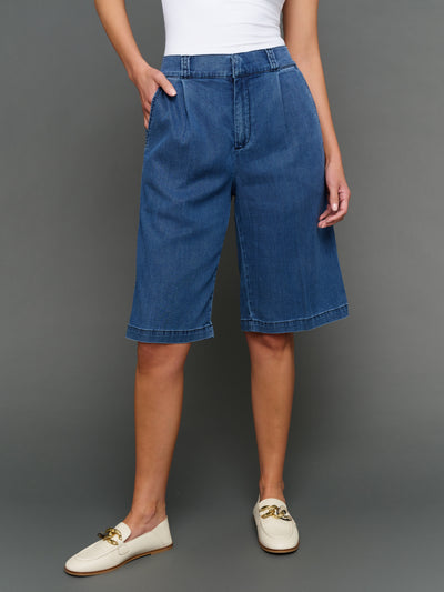 Model is wearing chambray bermuda short dark wash, front view.