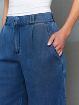 Model is wearing chambray bermuda short dark wash, close-up pocket detail.