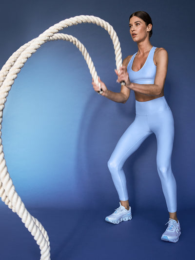 Model is wearing the Action Bra 2.0 and High Rise 7/8 Legging in Takara Shine in Serenity during training with battle ropes.