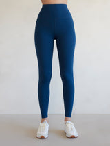 Front view of Diamond Compression high-rise leggings in French Navy on model with white sneakers.