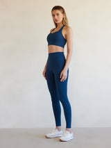 Side angle of model in French Navy Diamond Compression leggings and matching bra.